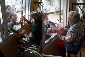 Adultos mayores de un geriátrico dan abrazos a sus seres queridos a través de una ventana intervenida